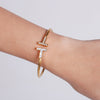 T bangle in gold with mother of pearl and stones